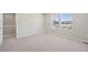 Empty bedroom featuring neutral carpet and multiple windows at 7312 Watercress Dr, Littleton, CO 80125