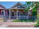 Charming home featuring a manicured lawn, a decorative fence, and hanging floral arrangements at 2941 Glenarm Pl, Denver, CO 80205