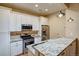Bright kitchen features stainless steel appliances, white cabinets and granite counters with pendant lighting at 2941 Glenarm Pl, Denver, CO 80205