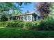 Landscaped front lawn and an exterior shot of a single-story house with large front-facing windows at 990 S Jackson St, Denver, CO 80209