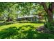 Beautiful home with a lush green lawn, mature trees, and professionally maintained landscaping at 990 S Jackson St, Denver, CO 80209