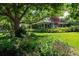 Well-manicured front yard with colorful flowers, a spacious lawn, and mature shade trees creating a serene setting at 990 S Jackson St, Denver, CO 80209