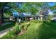 Landscaped front yard with a lush green lawn, blooming flowers, and a charming lamppost at 990 S Jackson St, Denver, CO 80209