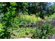 Lush garden view showcases a unique bird bath surrounded by colorful flowers and mature greenery at 990 S Jackson St, Denver, CO 80209