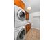 A functional laundry room with stacked washer and dryer and wooden cabinets at 990 S Jackson St, Denver, CO 80209