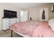 Comfortable bedroom featuring plush carpeting, neutral wall colors, dresser, and a wall mounted television at 381 S Ames St # G101, Lakewood, CO 80226