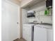 Bright laundry room with washer, dryer, shelving and a white door at 381 S Ames St # G101, Lakewood, CO 80226