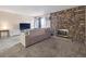 Cozy living room with stone fireplace, large window, and plush carpeting at 381 S Ames St # G101, Lakewood, CO 80226