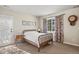 Bright bedroom with natural light, features neutral walls, white bedding, and hardwood floors at 5790 Fox Run Ct, Parker, CO 80134