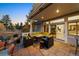 Relaxing covered patio with comfortable seating, a fire pit, and views of the manicured backyard at 5790 Fox Run Ct, Parker, CO 80134