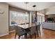 Open-plan dining area adjacent to a living room features hardwood floors and large windows for ample natural light at 5790 Fox Run Ct, Parker, CO 80134
