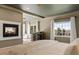 Relaxing bedroom with a fireplace, sitting area, and large windows showcasing beautiful views at 5790 Fox Run Ct, Parker, CO 80134