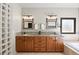 Double vanity with granite countertops, tile backsplash, and framed mirrors in a spacious bathroom at 5790 Fox Run Ct, Parker, CO 80134