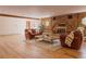Basement living room with a brick fireplace, wood floors, and comfortable furniture at 326 E Oak Hills Dr, Castle Rock, CO 80108