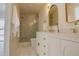 Bathroom featuring a double vanity with gold hardware, a glass enclosed shower, and marble tile at 326 E Oak Hills Dr, Castle Rock, CO 80108