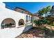 Inviting home exterior with stucco walls, tiled roof, arched openings, and a cozy bench at 326 E Oak Hills Dr, Castle Rock, CO 80108