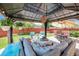 Backyard patio features lounge furniture, a canopy umbrella, a grill, plants and manicured lawn at 15776 E 107Th Way, Commerce City, CO 80022