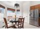 Kitchen nook features a pendant light, wood blinds, a round table and stainless steel refrigerator at 15776 E 107Th Way, Commerce City, CO 80022