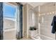 Bathroom featuring a tiled shower with a glass door and a view from the window at 2078 Wagon Wheel Aly, Brighton, CO 80601