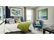 Bright bedroom with a comfortable bed, colorful artwork, and a cozy seating area at 2078 Wagon Wheel Aly, Brighton, CO 80601