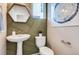 Stylish powder room featuring decorative wall paneling, a pedestal sink, and modern fixtures at 2078 Wagon Wheel Aly, Brighton, CO 80601