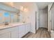 Modern bathroom featuring dual sinks with quartz countertop, wood-look laminate flooring, and walk-in shower at 14139 Bunny Hop Ln, Parker, CO 80134