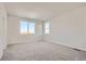 Spacious bedroom featuring neutral carpet, two large windows, and light gray walls at 14139 Bunny Hop Ln, Parker, CO 80134