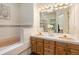 Bathroom with dual vanities, a bathtub, and a separate shower, offering a spa-like experience at 7915 Flower St # D, Arvada, CO 80005