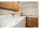 Convenient laundry room with washer, dryer, sink, and ample cabinet space at 7915 Flower St # D, Arvada, CO 80005