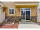 Cozy patio area with sliding glass doors, a compact concrete slab, and mulch landscaping for low-maintenance outdoor living at 9980 W Jewell Ave # B, Lakewood, CO 80232