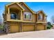 Townhome exterior featuring multiple garages and an upper-level balcony, with neutral tones and stone accents at 9980 W Jewell Ave # B, Lakewood, CO 80232