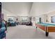 Open basement with seating, a pool table, windows offering views, and carpet flooring at 15290 W Baker Ave, Lakewood, CO 80228