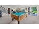 Spacious basement area with a pool table, carpet flooring, and access to the backyard at 15290 W Baker Ave, Lakewood, CO 80228