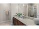 Bathroom featuring a long granite vanity with wood cabinets and a glass-enclosed shower at 15290 W Baker Ave, Lakewood, CO 80228