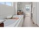 Soaking tub in the bathroom has a stone tile surround, and a mountain view from the doorway at 15290 W Baker Ave, Lakewood, CO 80228