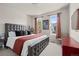 Bedroom with large upholstered bed, two windows and neutral decor with accent colors at 15290 W Baker Ave, Lakewood, CO 80228