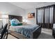 Comfortable bedroom with a large upholstered headboard, gray bedding, and modern art at 15290 W Baker Ave, Lakewood, CO 80228