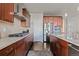 Well-equipped kitchen with stainless steel appliances, dark cabinets, and granite countertops at 15290 W Baker Ave, Lakewood, CO 80228