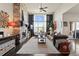 Bright living room with stone fireplace, ceiling fan, and large window at 15290 W Baker Ave, Lakewood, CO 80228