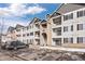 Beige three-story building with gray accents at 15700 E Jamison Dr # 7-205, Englewood, CO 80112