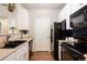 Modern kitchen with black appliances and white cabinets at 15700 E Jamison Dr # 7-205, Englewood, CO 80112