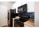 Modern kitchen with black appliances and white cabinets at 15700 E Jamison Dr # 7-205, Englewood, CO 80112