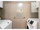 Laundry area with washer, dryer, and shelving at 15700 E Jamison Dr # 7-205, Englewood, CO 80112