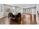 Open floor plan connecting dining and living spaces with hardwood floors and large windows at 6041 S Salida Ct, Aurora, CO 80016