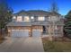 Charming two-story home with a brick and light blue exterior, well-manicured lawn, and an attached two-car garage at 6041 S Salida Ct, Aurora, CO 80016