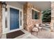 Inviting front porch with brick accents, seating, and a charming blue front door at 6041 S Salida Ct, Aurora, CO 80016