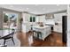Well-lit kitchen with a center island, seating, stainless appliances, and sliding glass doors to backyard at 6041 S Salida Ct, Aurora, CO 80016