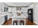 Bright kitchen with stainless steel appliances, white cabinetry, and a large center island at 6041 S Salida Ct, Aurora, CO 80016