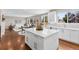 Open-concept kitchen featuring white cabinetry, a center island, and seamless integration with living areas at 6041 S Salida Ct, Aurora, CO 80016