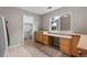 Functional laundry room with a large window, built-in cabinets, counter space, and tile flooring at 6041 S Salida Ct, Aurora, CO 80016